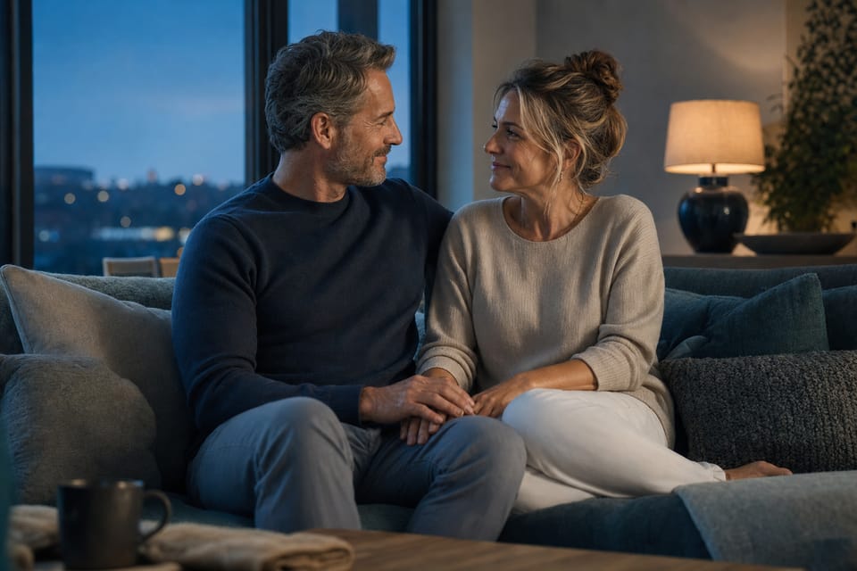 A fully clothed adult couple sharing a warm, quiet moment at home